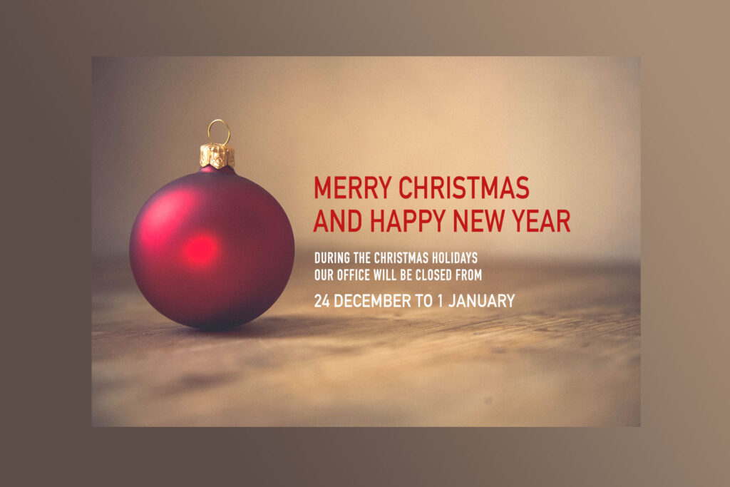 Merry Christmas and Happy New Year: office closed from 24 December to 1 January, red Christmas bauble on a wooden surface.